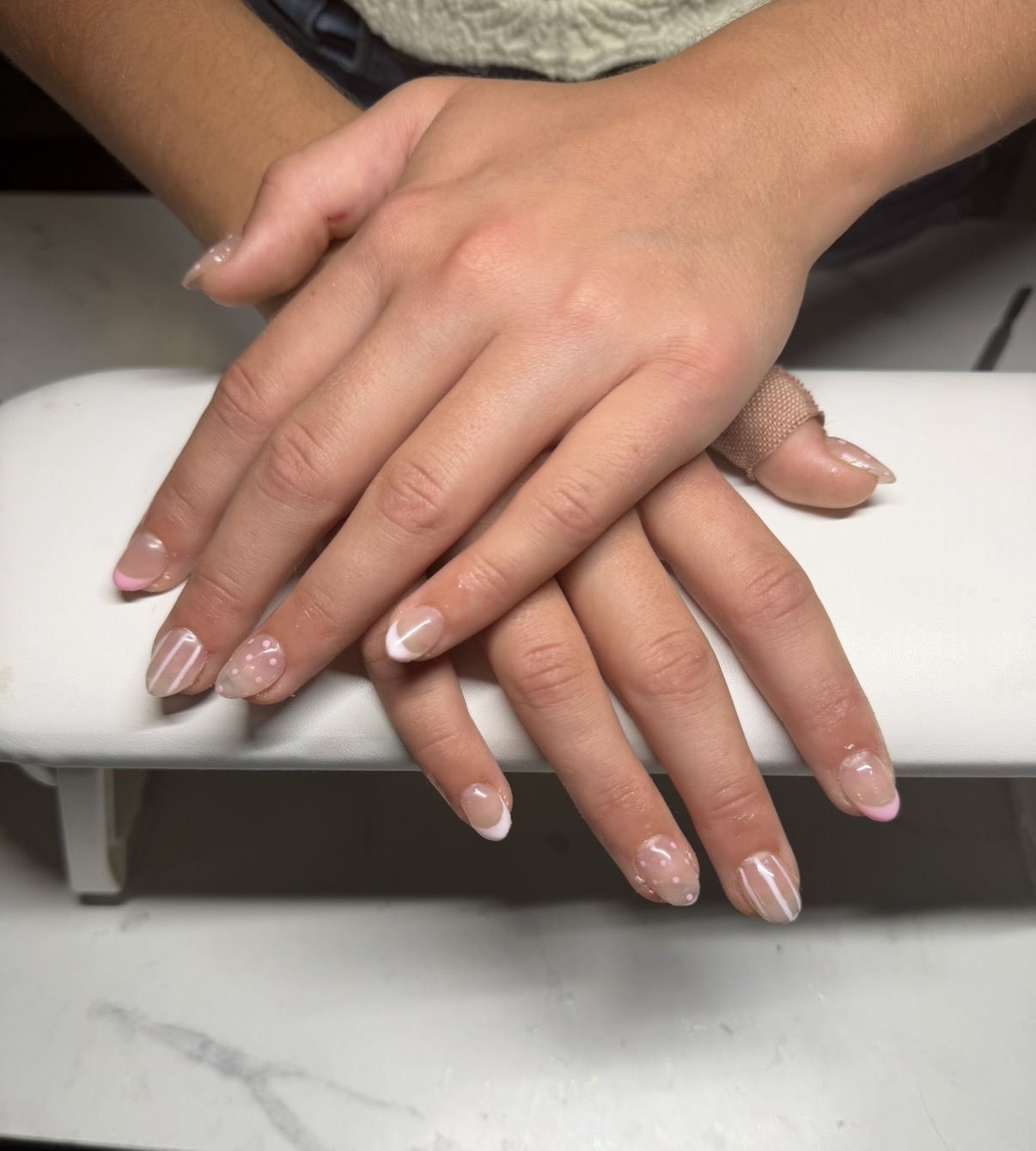 Pearl bow accent gel nail set with soft pink and white details by Raegan
